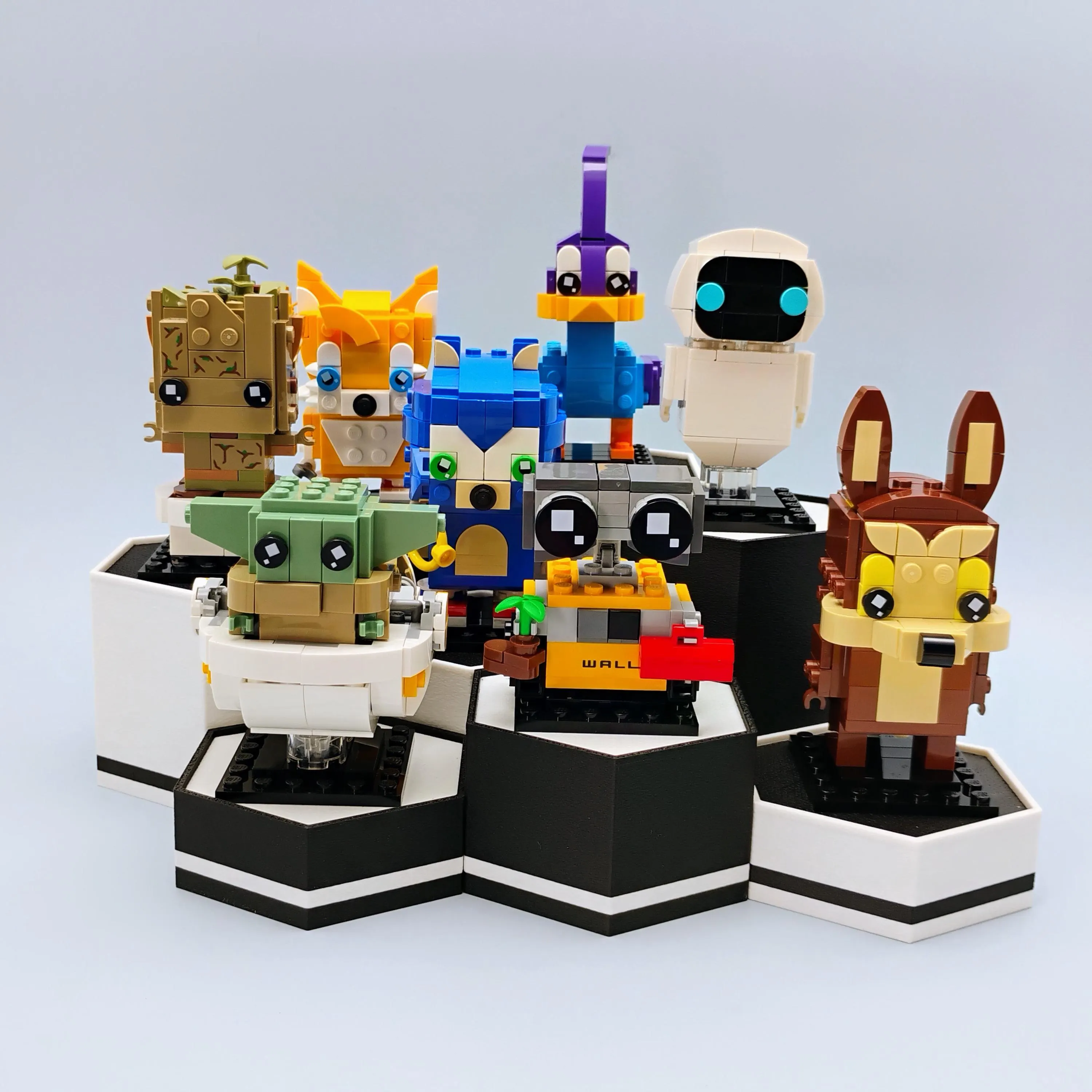 Hexagonal display stands for LEGO® BrickHeadz and Funko Pops in matte black and white. Modular collectible stands for shelf dioramas and desk displays.