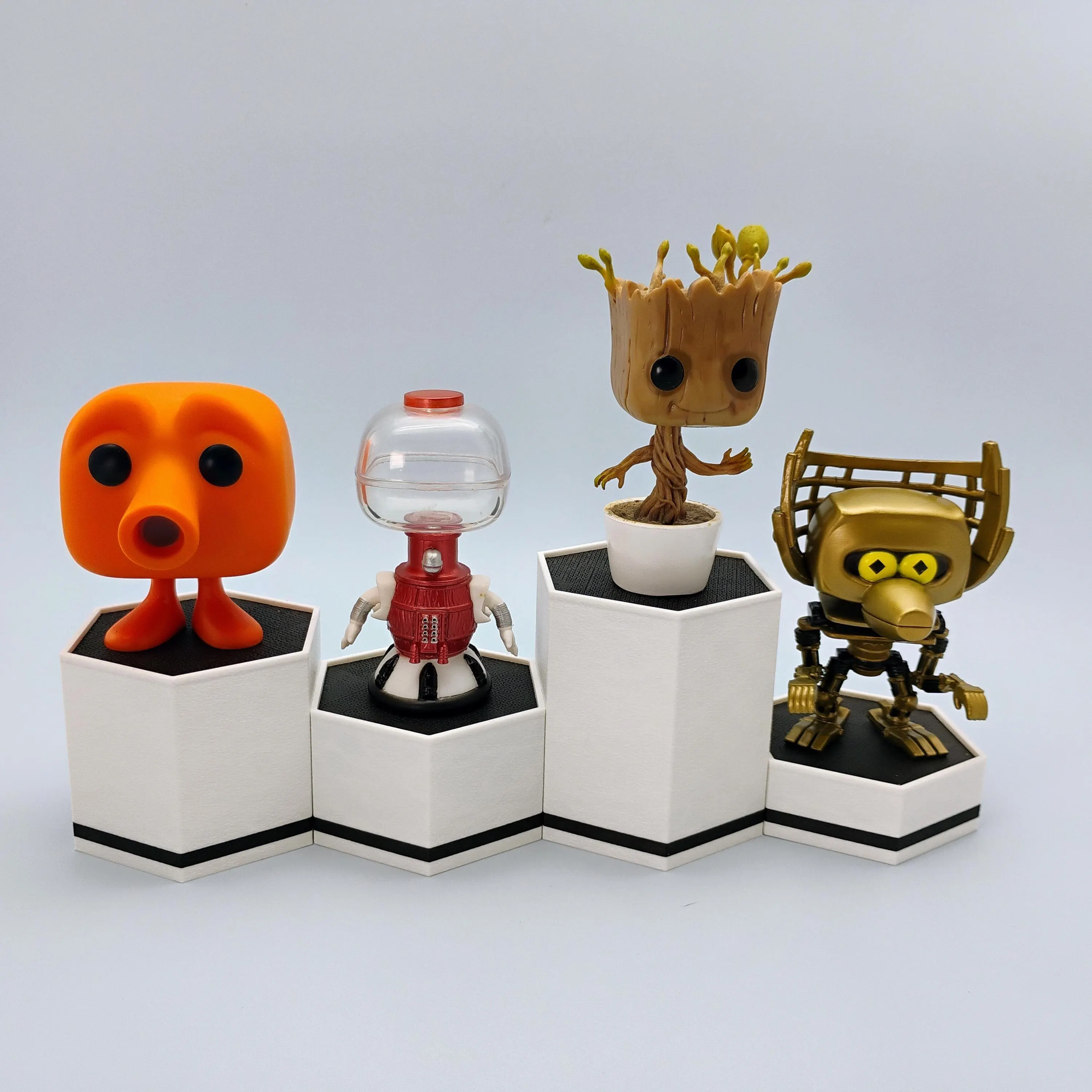 Funko Pop figures displayed on matte white hexagonal stands with bold accent color variations.
