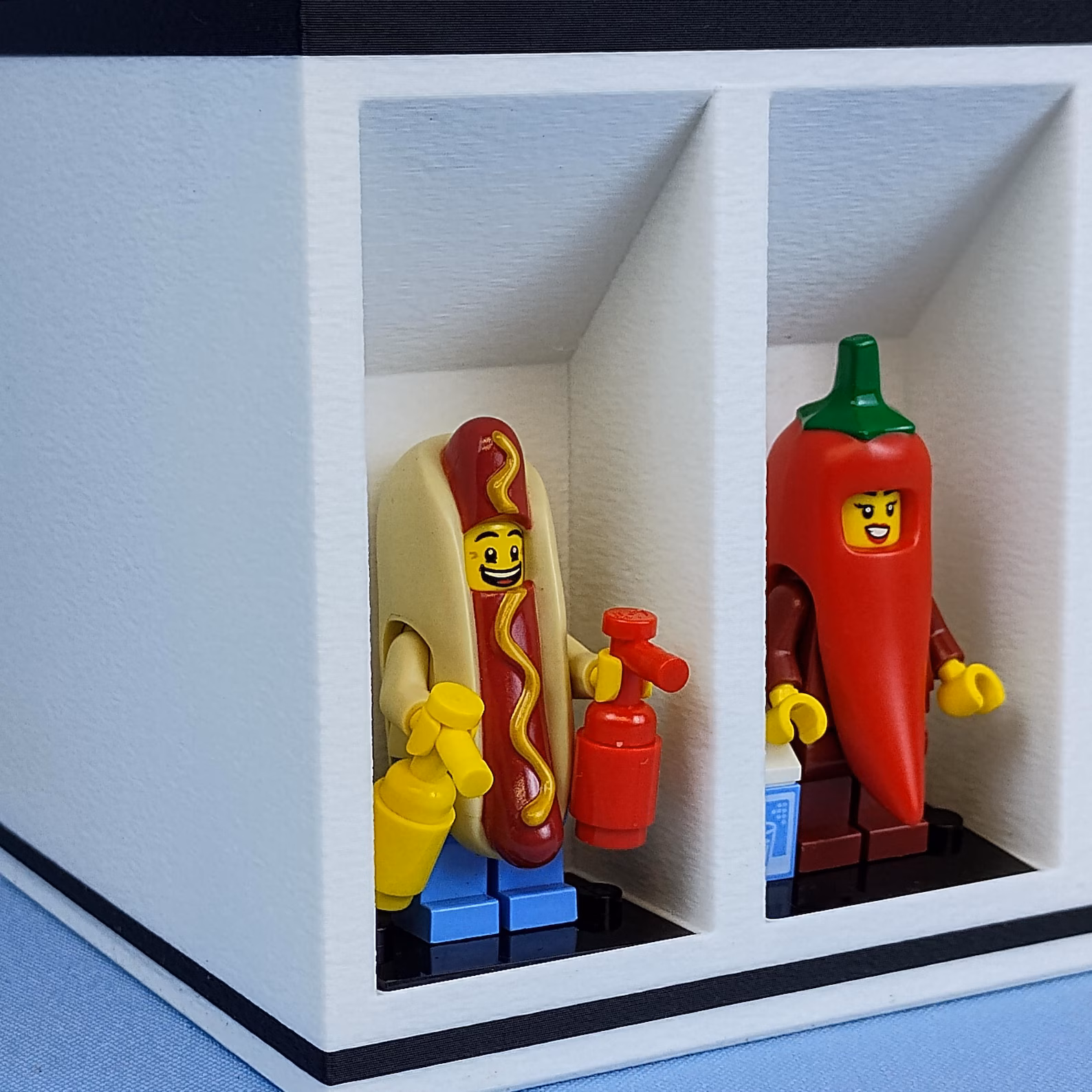 Close-up detail of desk organizer display compartments showing how minifigures fit securely in individual cubbies. Highlights the clean edges and organized layout.